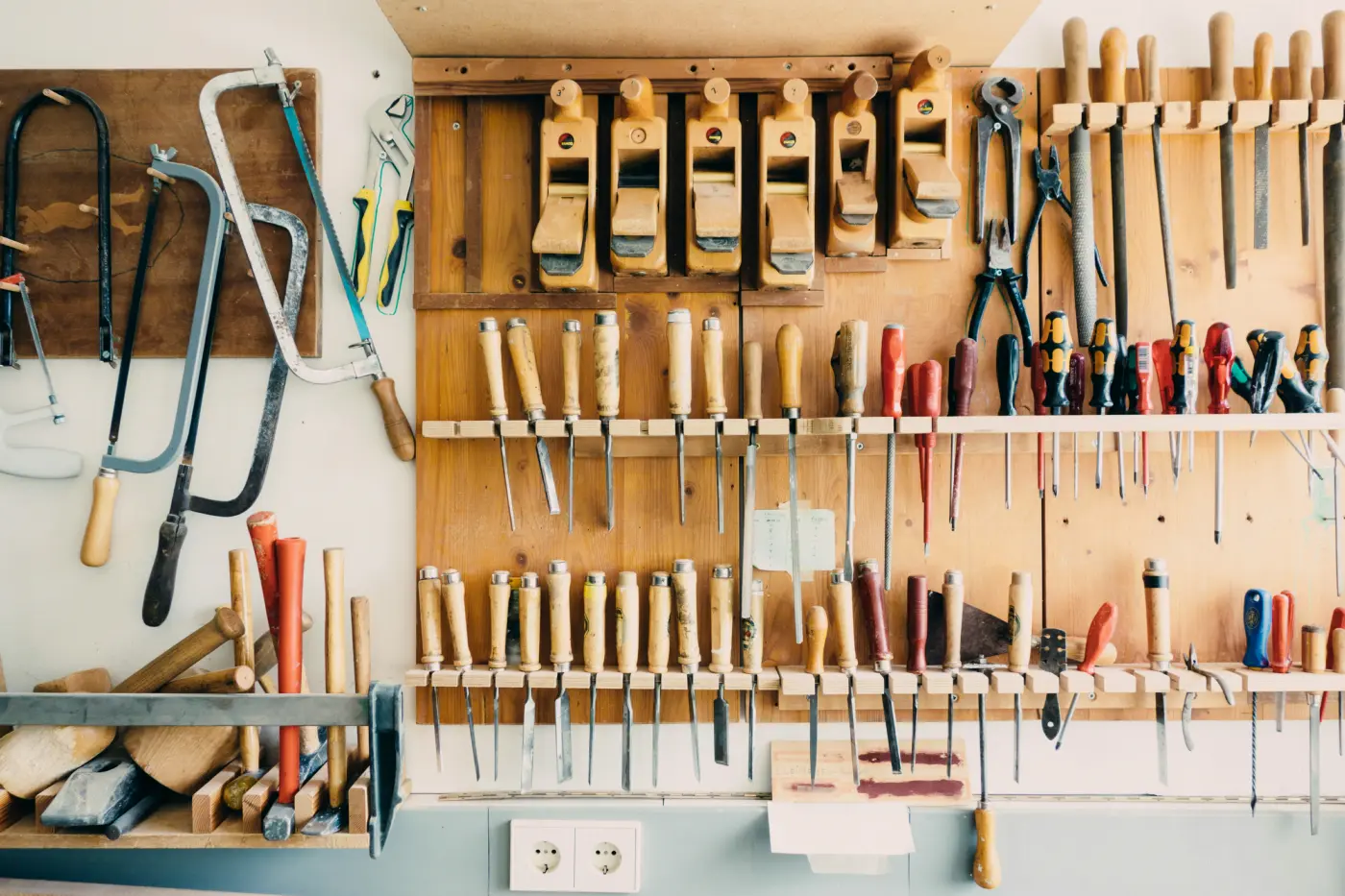 Atelier de menuiserie : rabots, ciseaux à bois et outils suspendus au mur